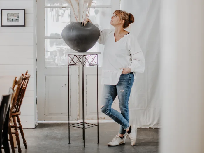 Entrén till L’ Atelier med Linda Pihl bredvid en stor vas