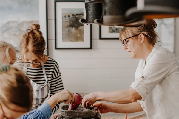 Vänner skapar tillsammans vid bordet under Kreativ Afterwork